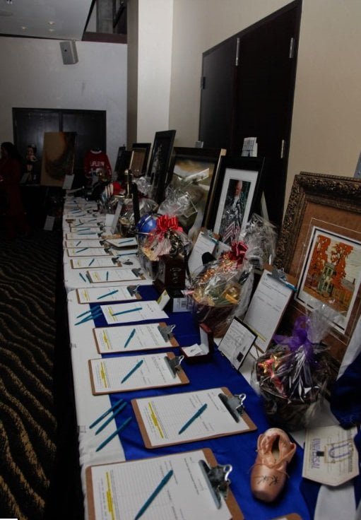 Silent auction table brimming with prizes.
